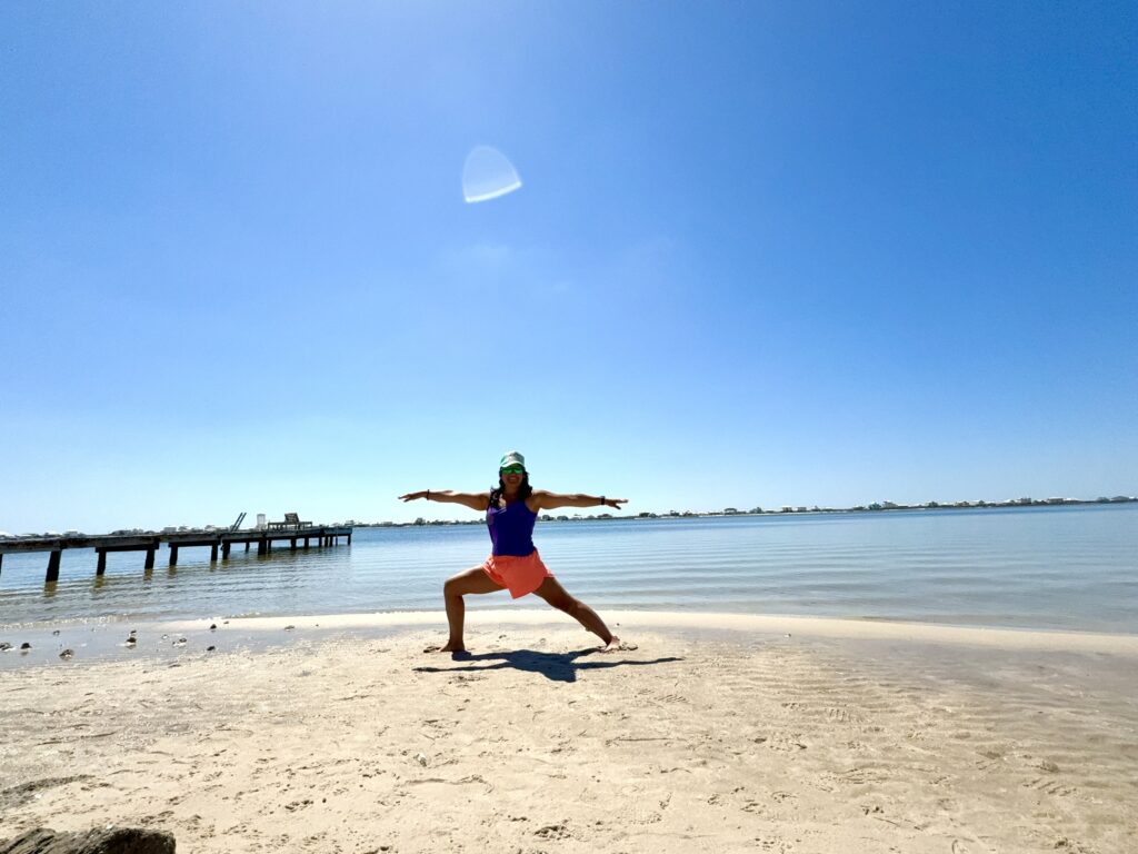 girl doing yoga on the beach