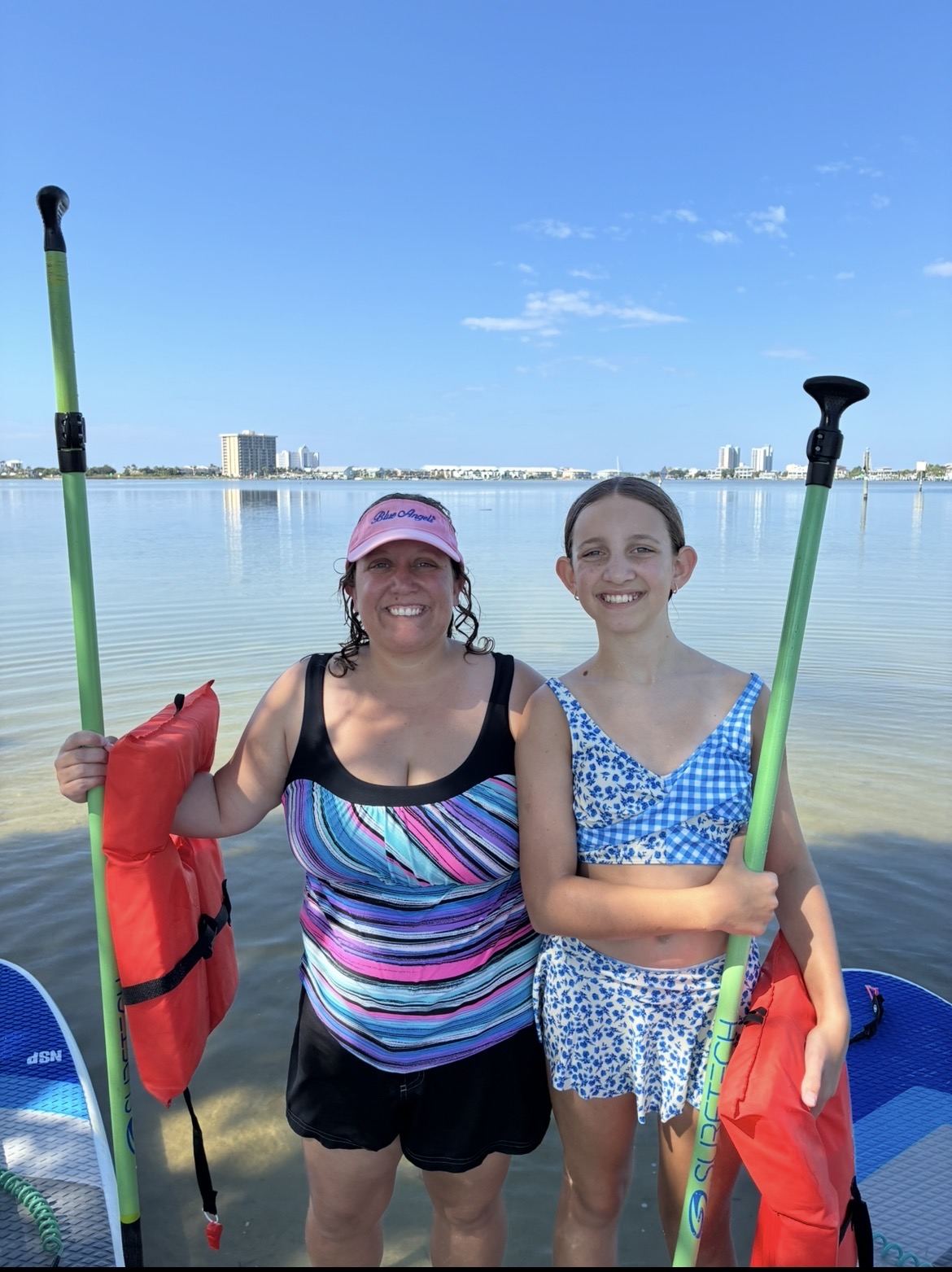 2 girls getting ready to go stand up paddle boarding in pensacola beach