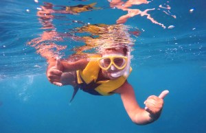 man snorkeling in Hawaii with a lifejacket on 