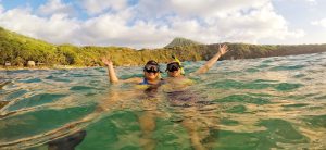 couple snorkeling at Hanauma Bay with Koko head in the background