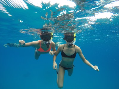 Two girls snorkeling in clear water at Pure Aloha Adventures in Oahu