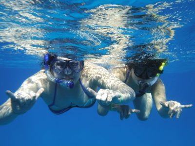 2 girls snorkeling in blue water