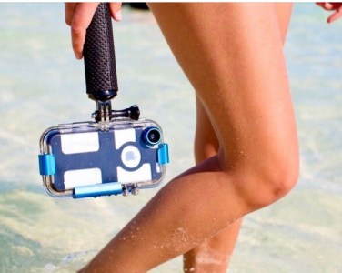 a woman holding an underwater iPhone case near her legs