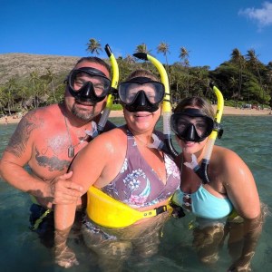 a group of people standing the water with snorkel gear on