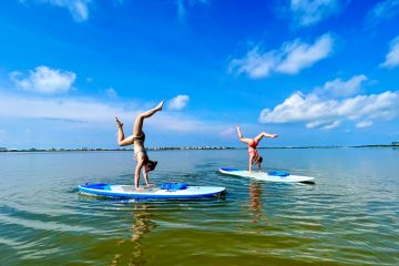 2 girls doing paddle board yoga